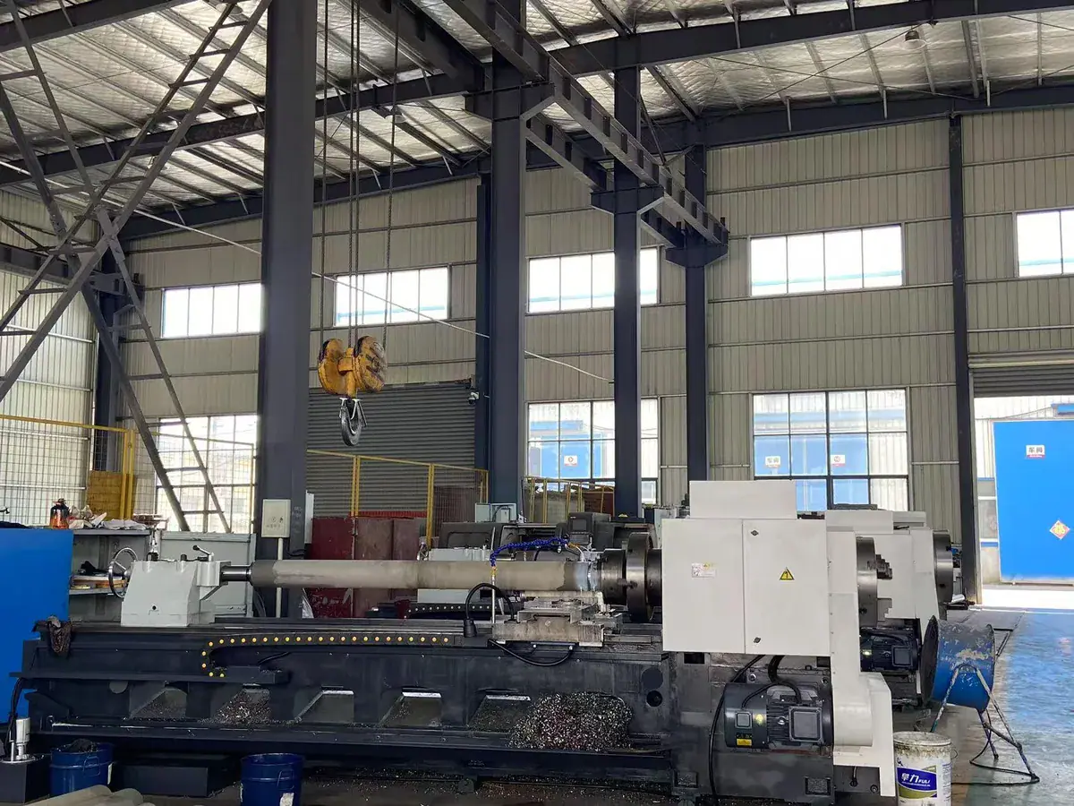 Large-bed machining equipment beneath an overhead crane in a workshop