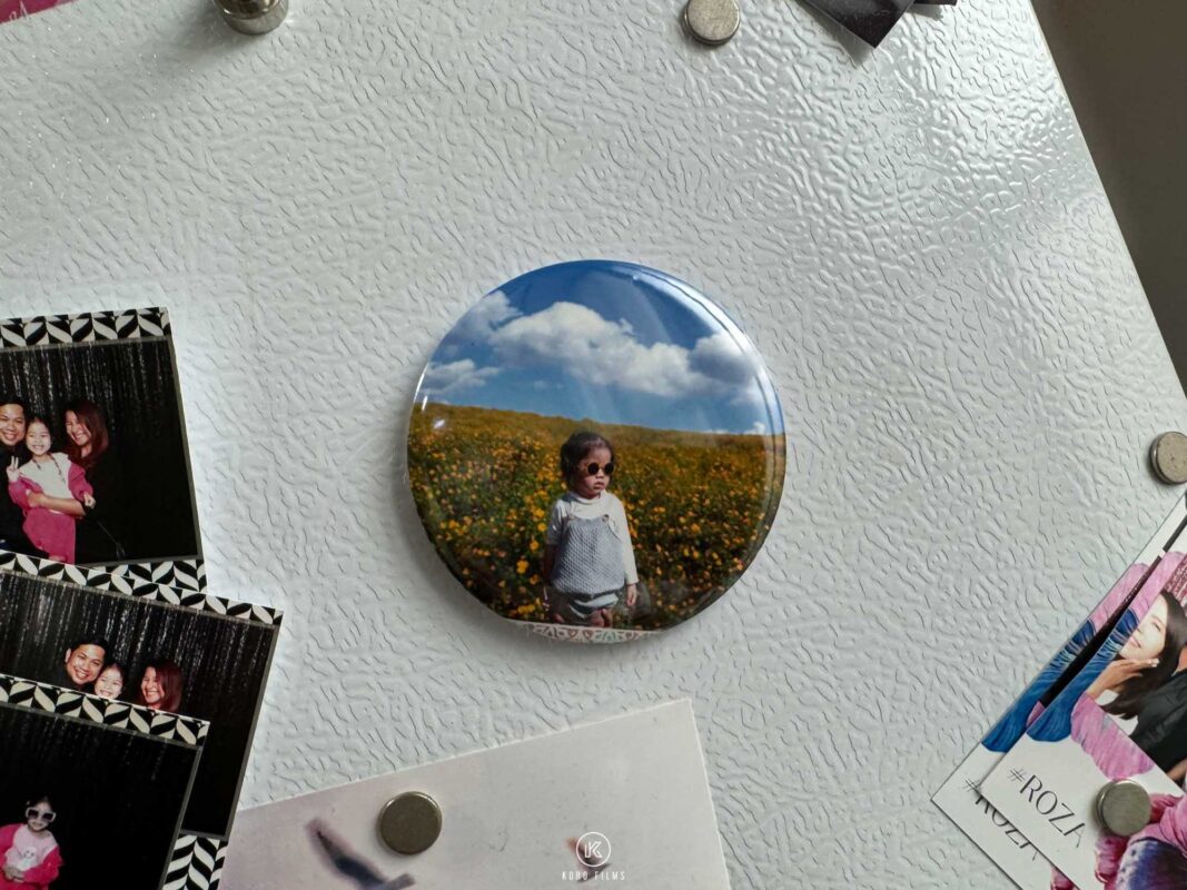 Round photo fridge magnet of a child in a flower field on a white fridge