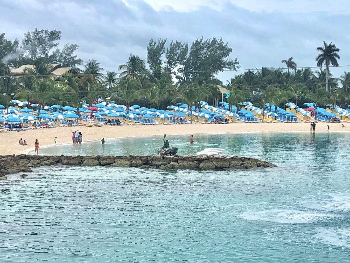 Beach with lounge chairs and blue umbrellas