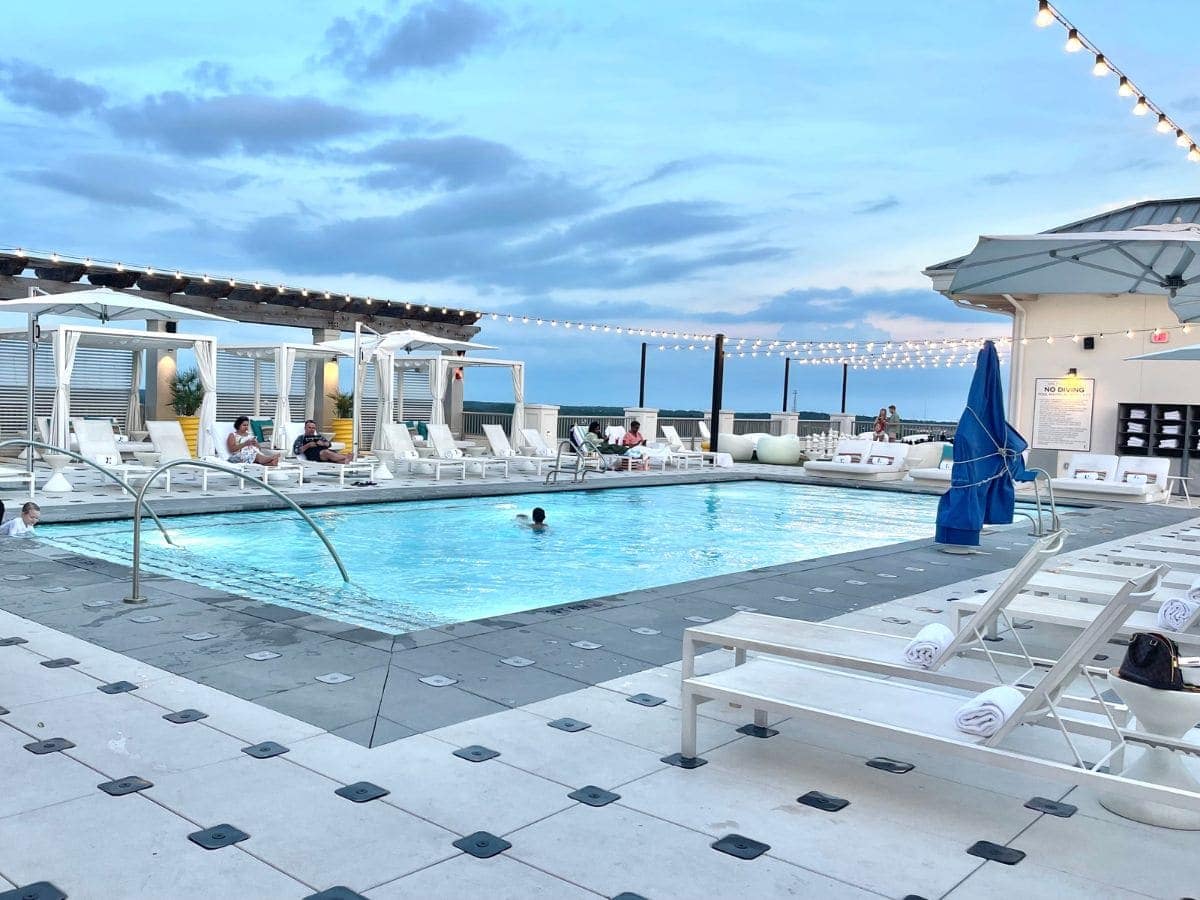 Rooftop Pool with loungers and lights hung