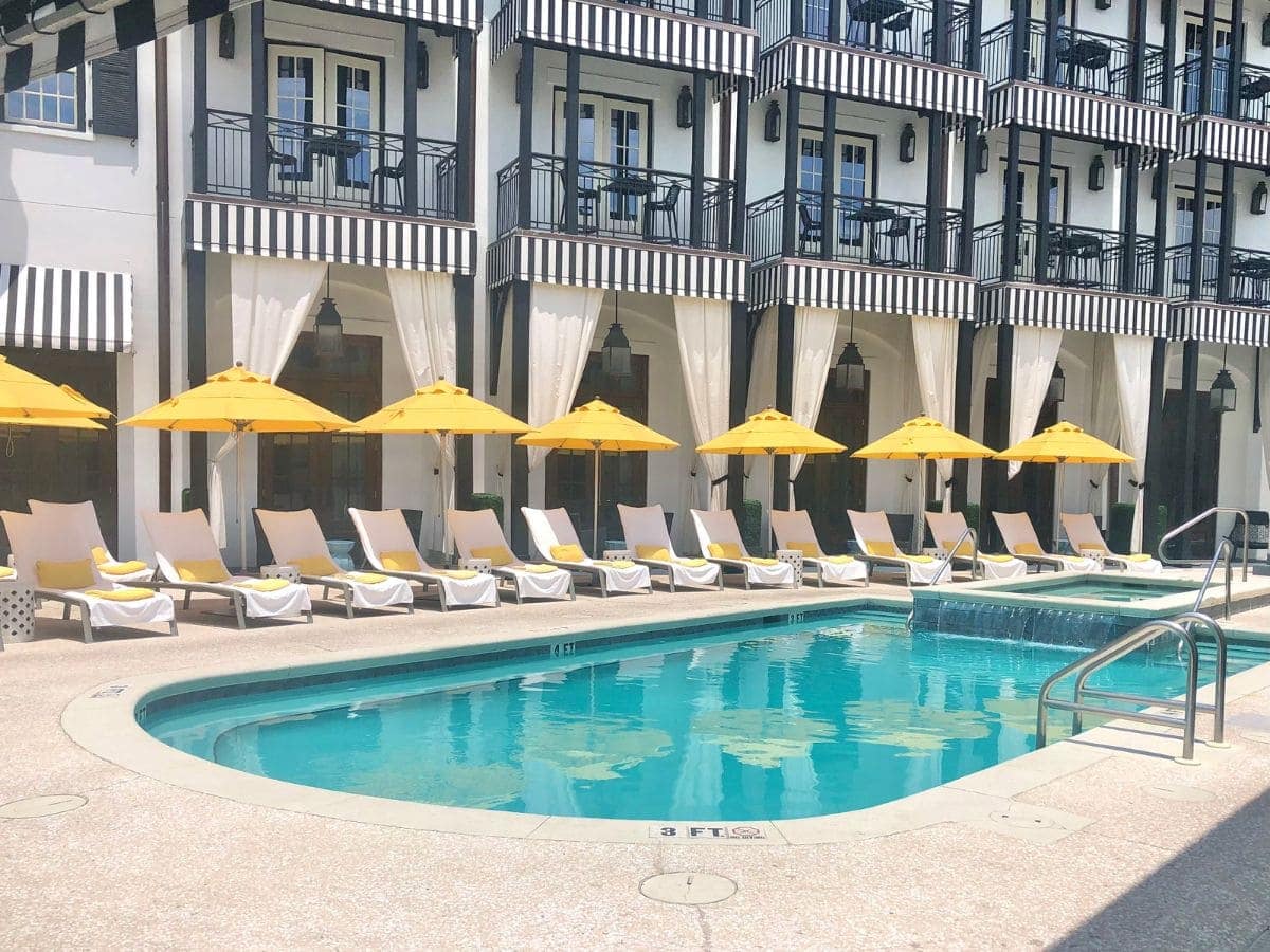 Balconies at The Pearl overlooking the pool with chairs and yellow umbrellas