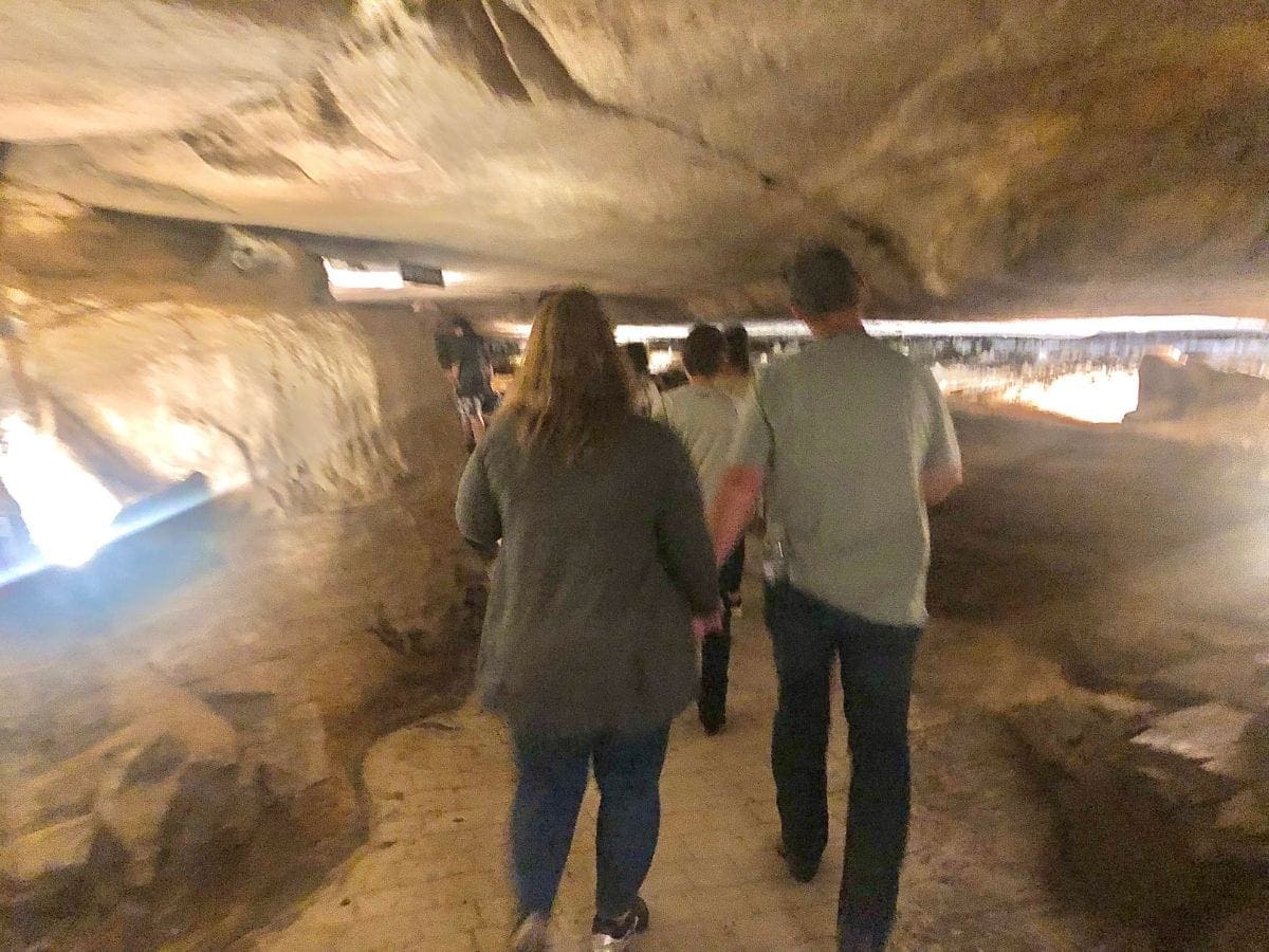 people walking through cave on tour