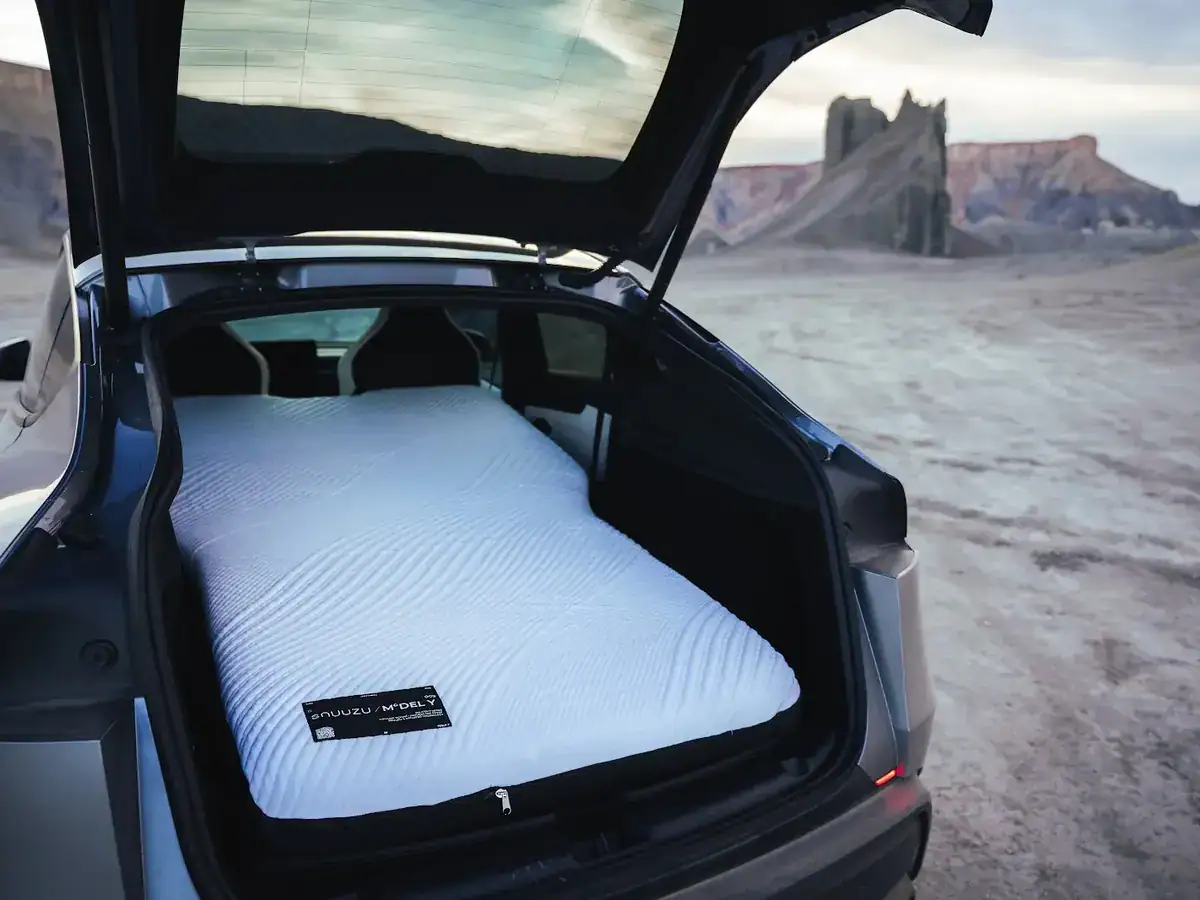 Snuuzu-matras in de kofferbak van een Tesla Model Y in een rotslandschap
