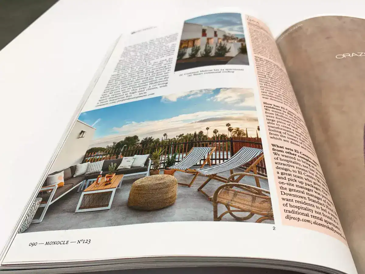 Modern rooftop terrace with lounge chairs, outdoor sofa, and wooden accents, under a partly cloudy sky.