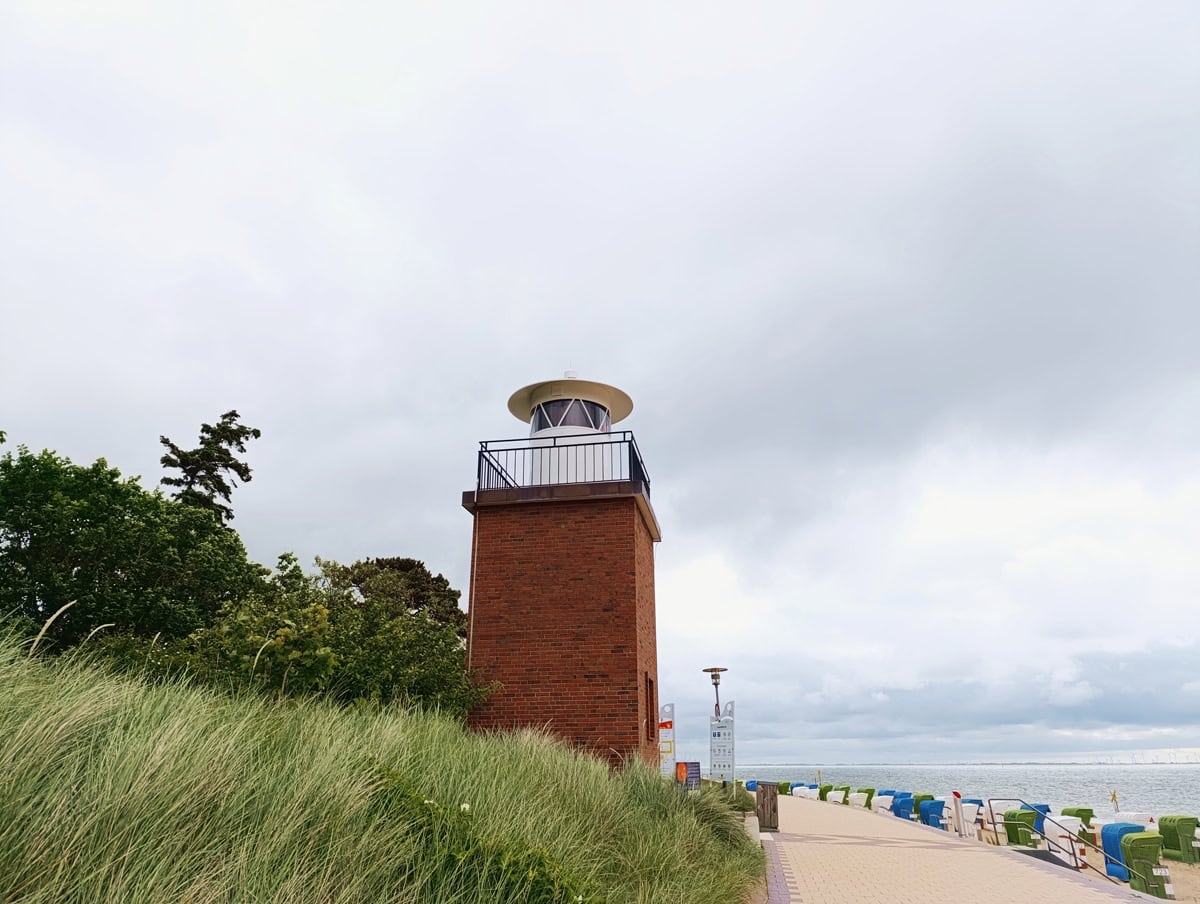 Freizeitschnack Nordfriesland wandert auf Föhr. Ein Blick auf den Leuchtturm, den Strand mit seinen Strandkörben und die Nordsee.