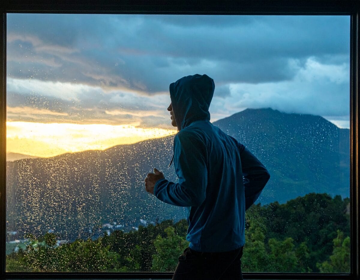 雨の中フードを被ってランニングしている様子。どんな環境でも継続させる意志。