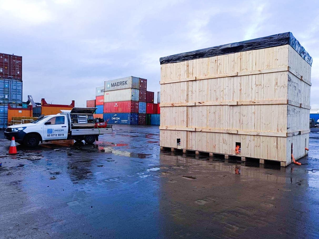 crate n pack solutions ute and wooden shipping crate with shipping containers in background