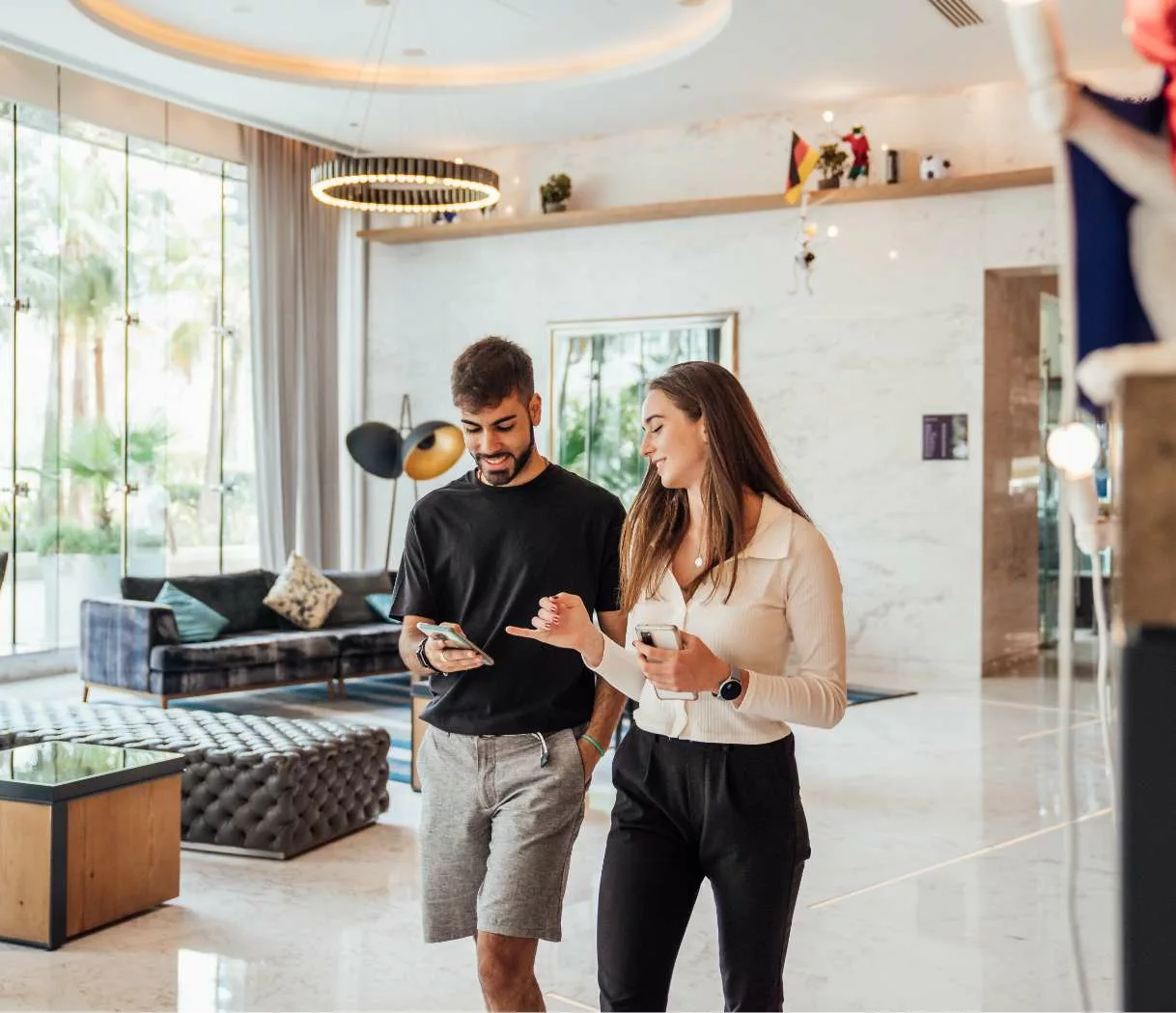 ot-2 A couple walking through the hotel looking at a phone together.