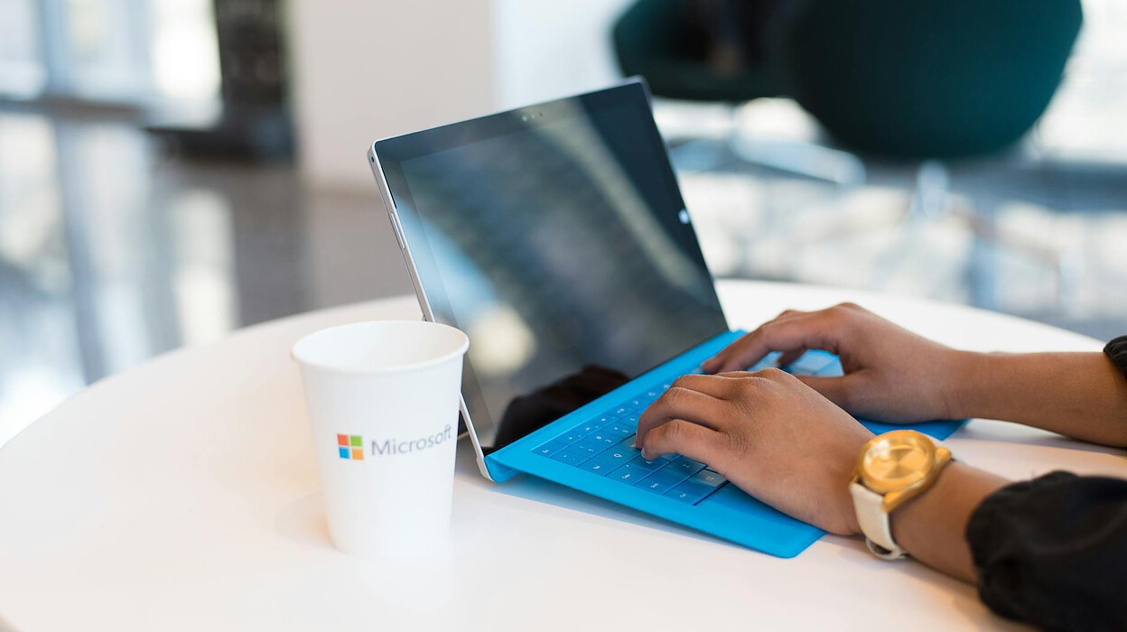 person browsing on black and blue laptop computer
