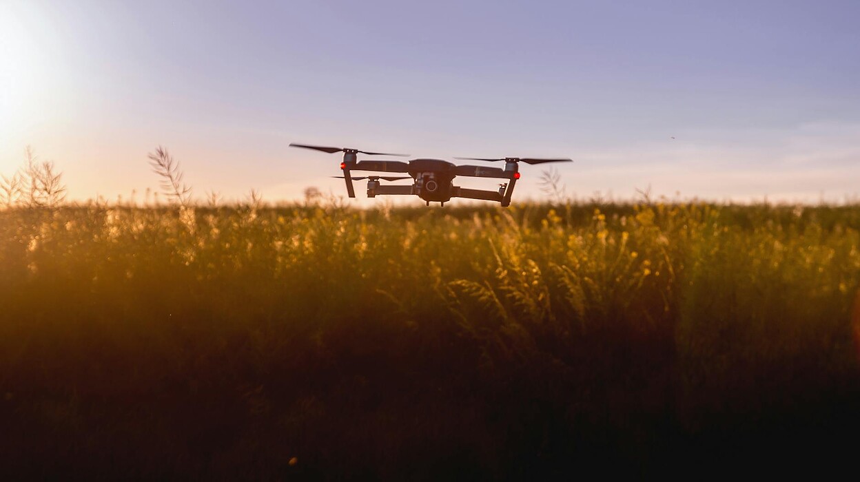 black quadcopter drone on green grass field