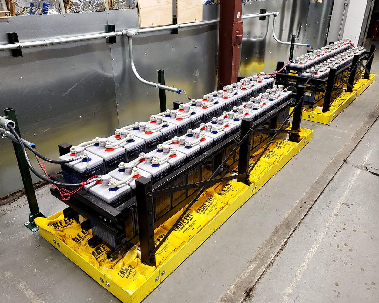 Flooded lead acid batteries on an angle with Eagle Eye Power Solutions spill containment pillows under the battery racks.