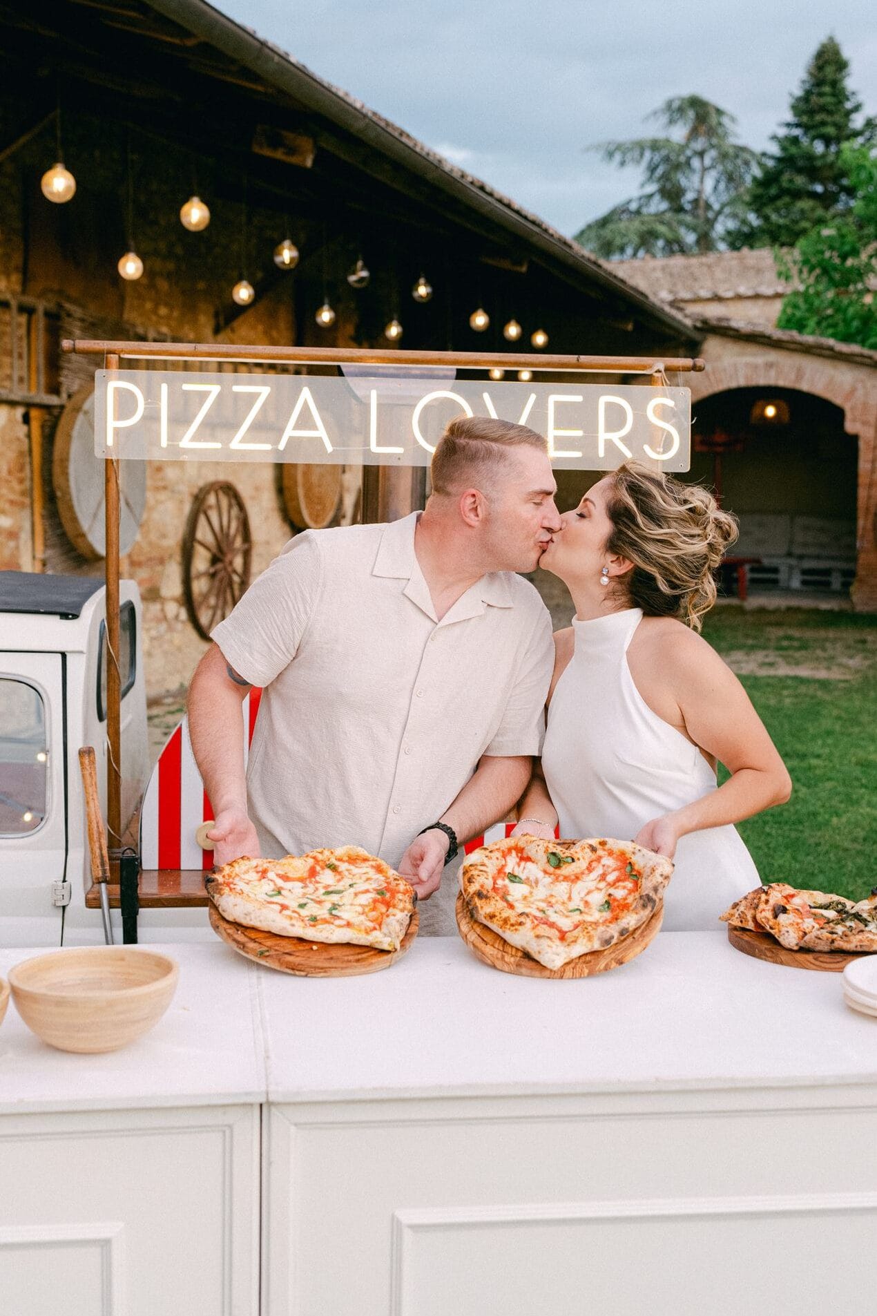 Couple making pizza together before their Italy wedding