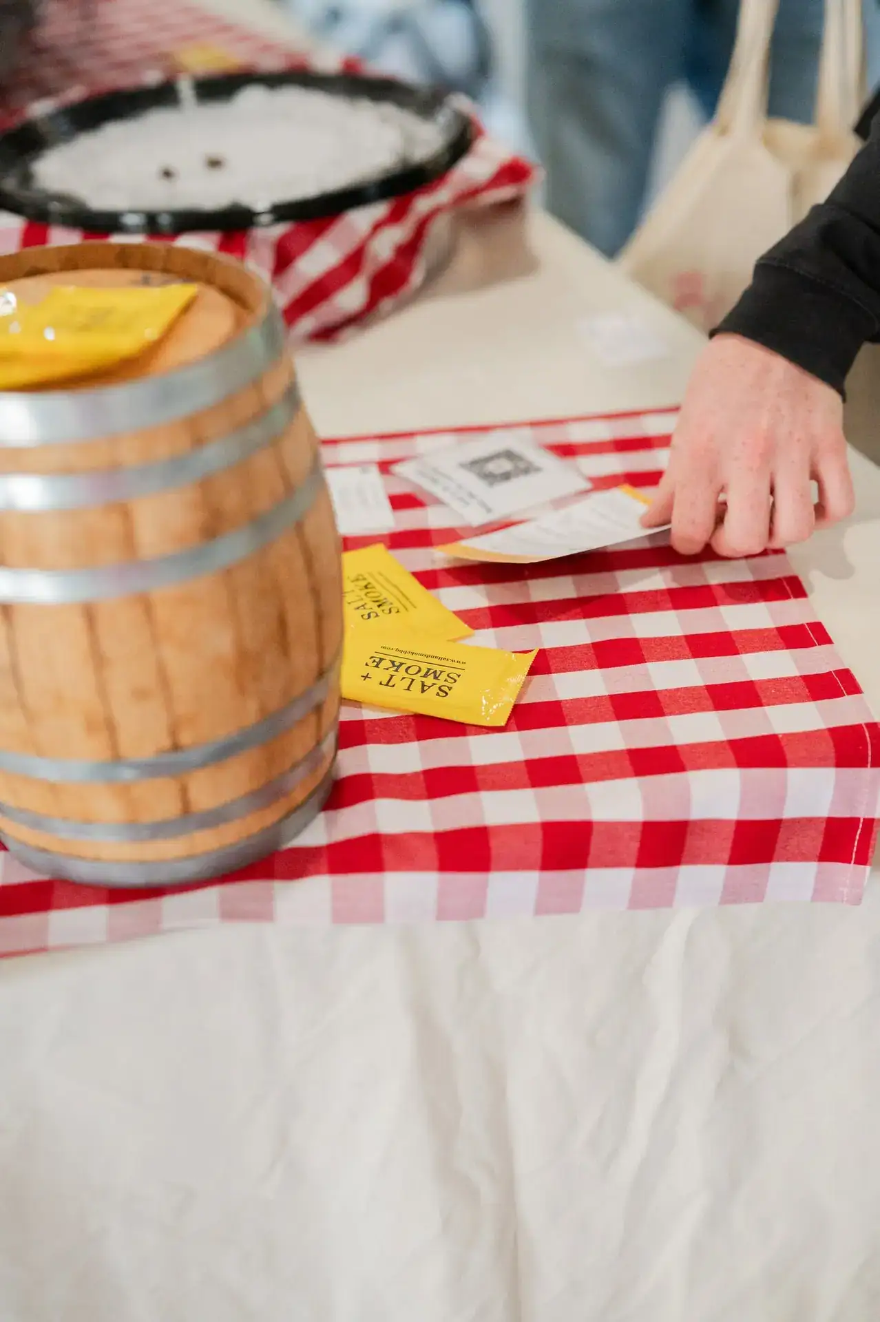 Wine barrel with red gingham linen and raffle tickets at a reception at Romaine Valley Weddings & Events in Fenton, Missouri