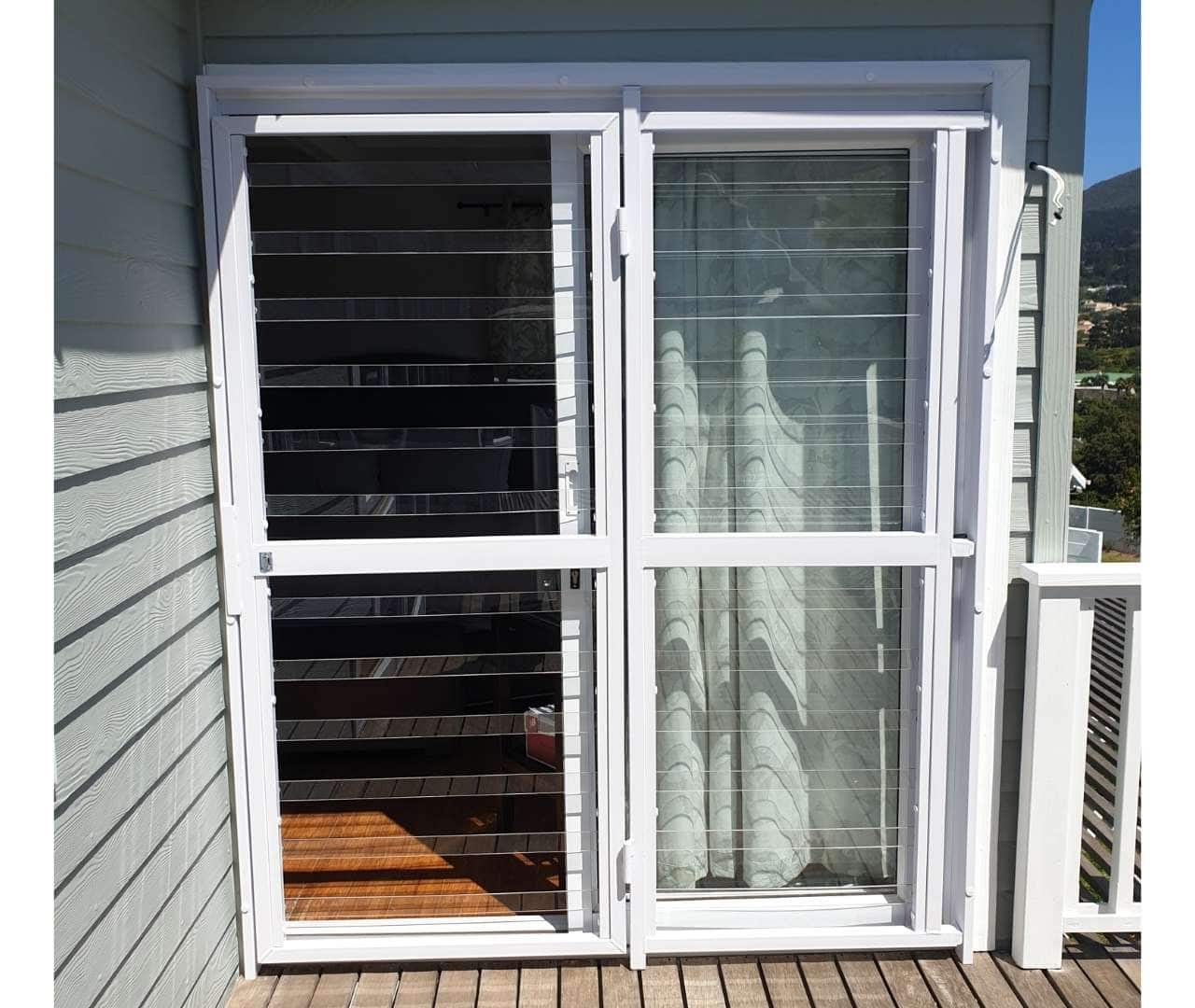 Corner perspective of home with twin clearview gate installations guarding patio doors and side windows for seamless perimeter security.