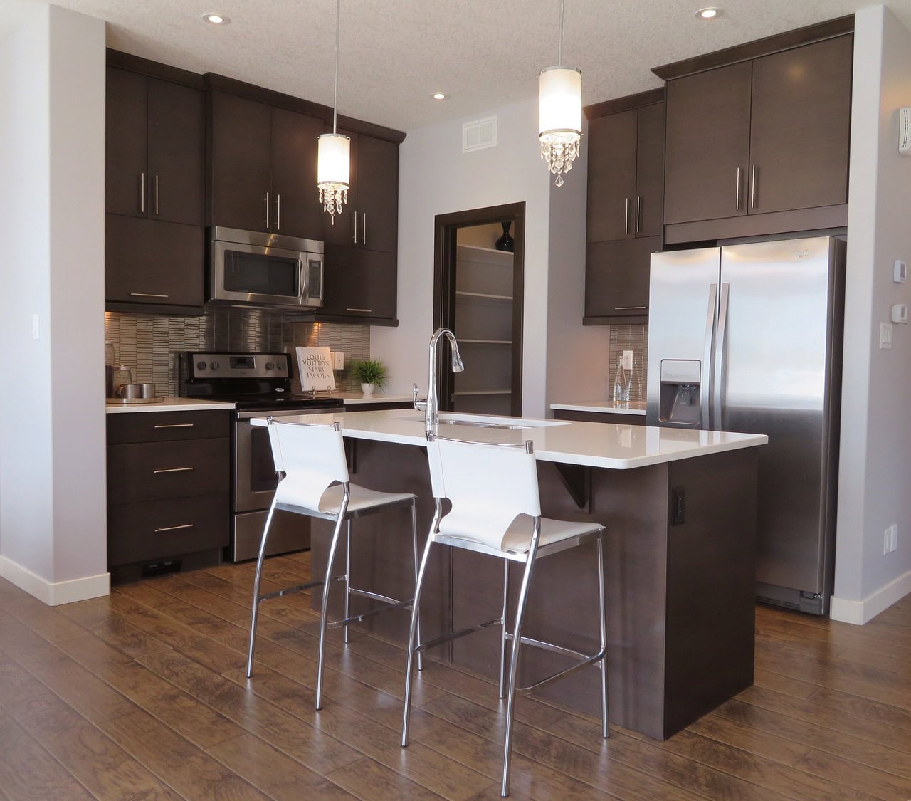 Kitchen setting with stools and American style fridge freezer. All items newly cleaned and shining.