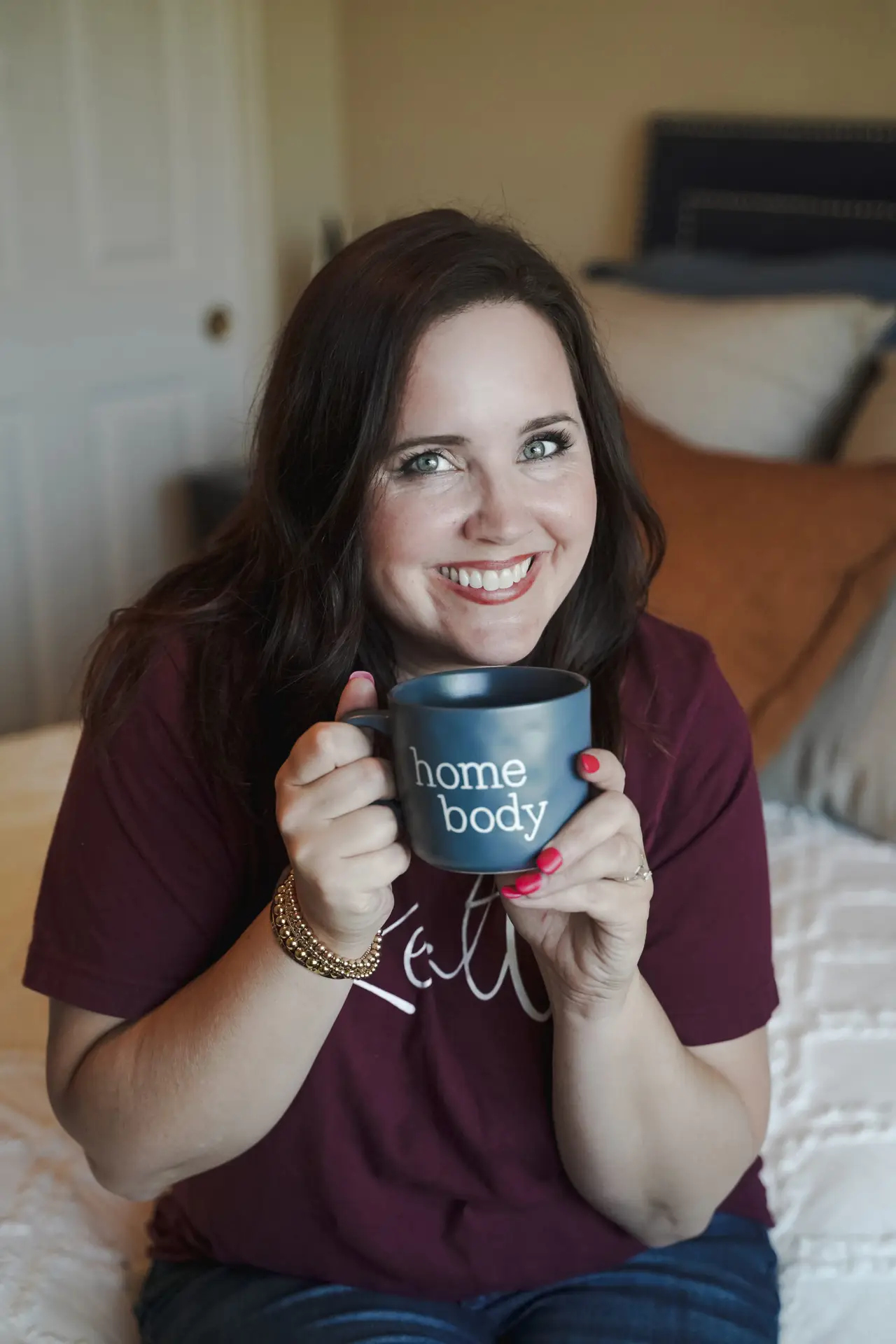 Jaydee Sheppard real estate services holding a Home Body mug and smiling