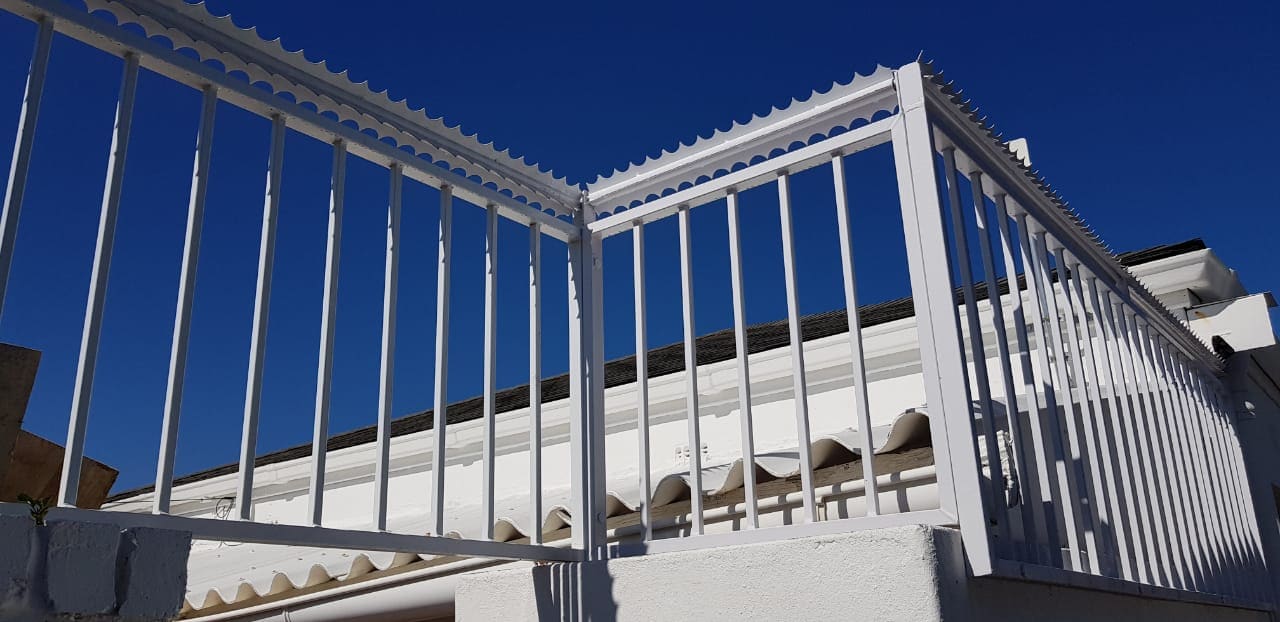 White rotating security spikes installed on a zig-zag fence panel installation on top of a balcony in Cape Town.