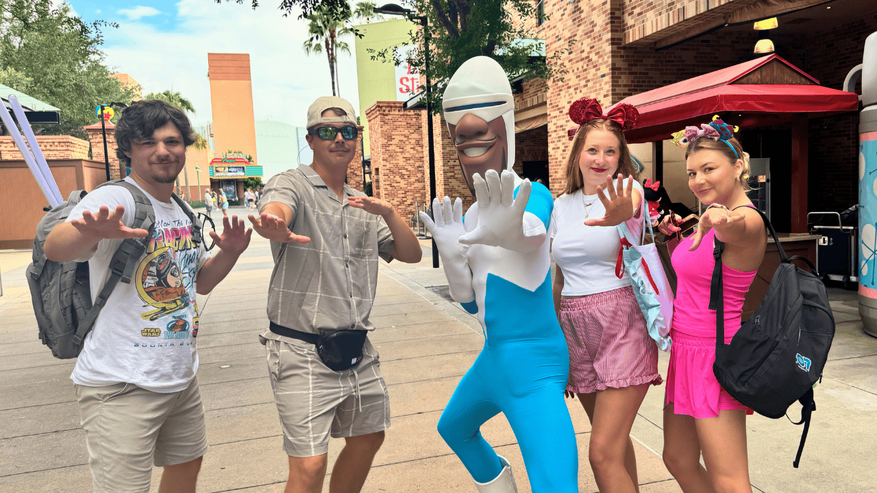 Family with Disney characters at a theme park enjoying a fun day.