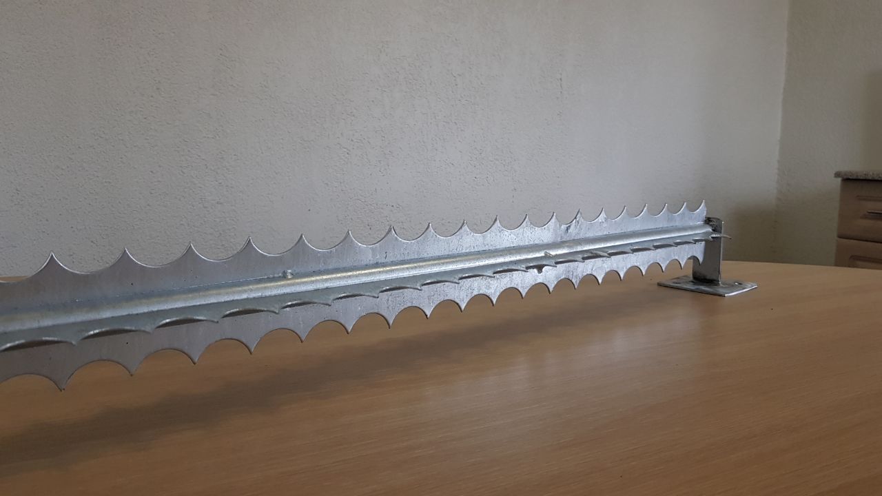 Galvanised steel rotating security spikes laid on a table, photographed at a cinematic angle.