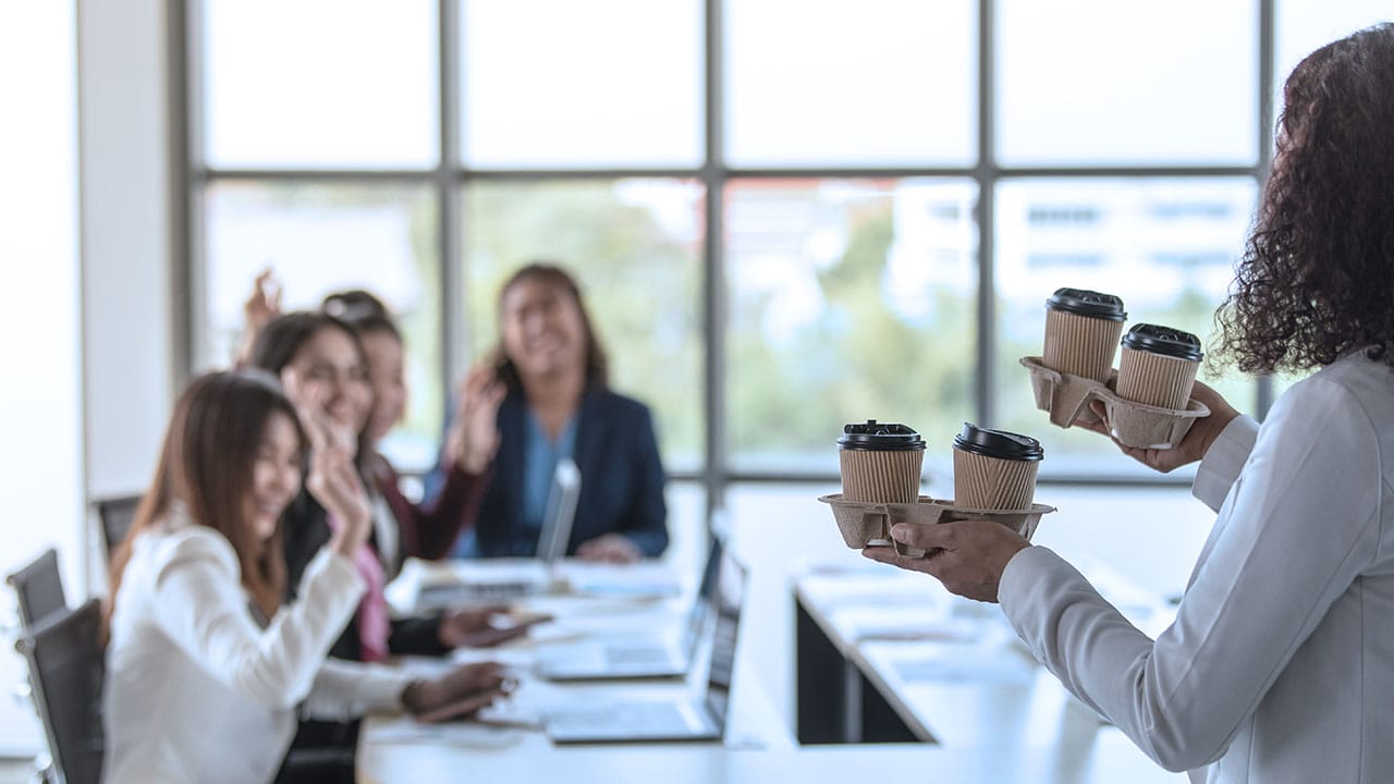 A manager delivering take out coffee to her team