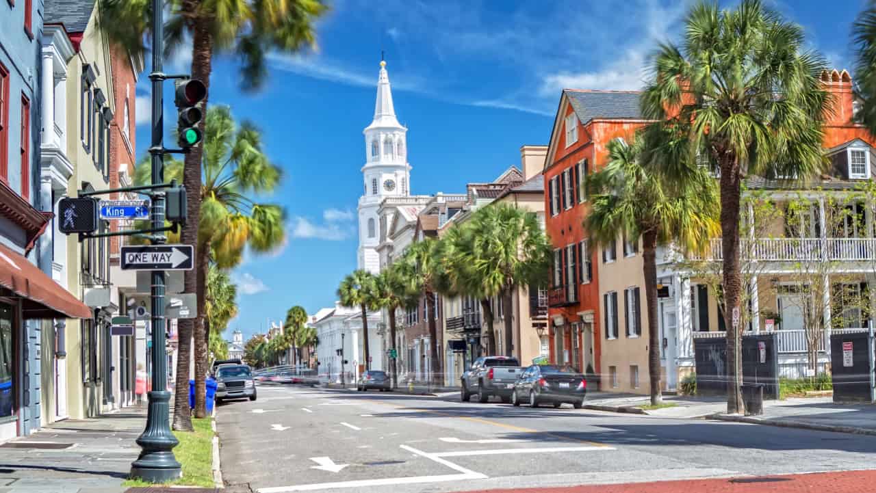 Colorful historic downtown street in Palmetto, Florida with palm trees and cloudy blue sky; ideal for vacation travel.