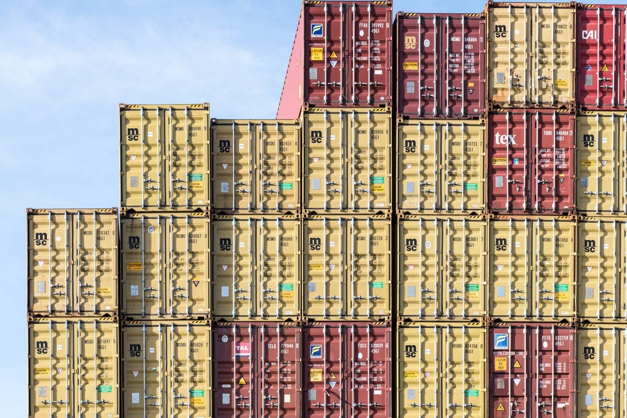 Colorful stacked shipping containers at Hamburg port, showcasing global trade and logistics.