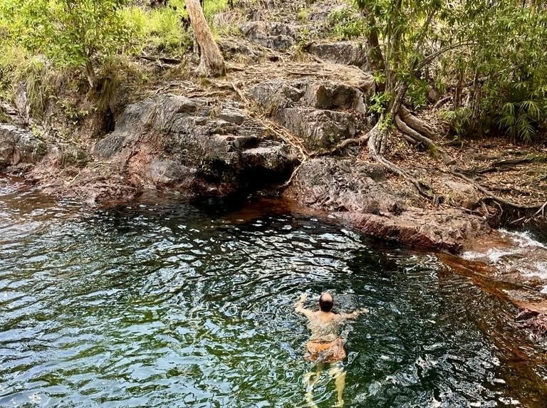 man swimming in a natural fresh water pool in australia