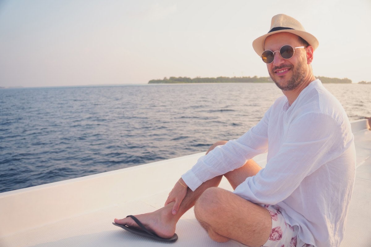 Person sitting on the deck of a boat during a sunset excursion from Reethi Faru Resort in the Maldives