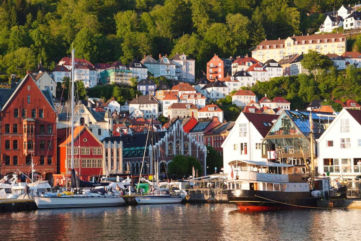 View of bergen harbour with houses and a mountain backdrop, during golden hour