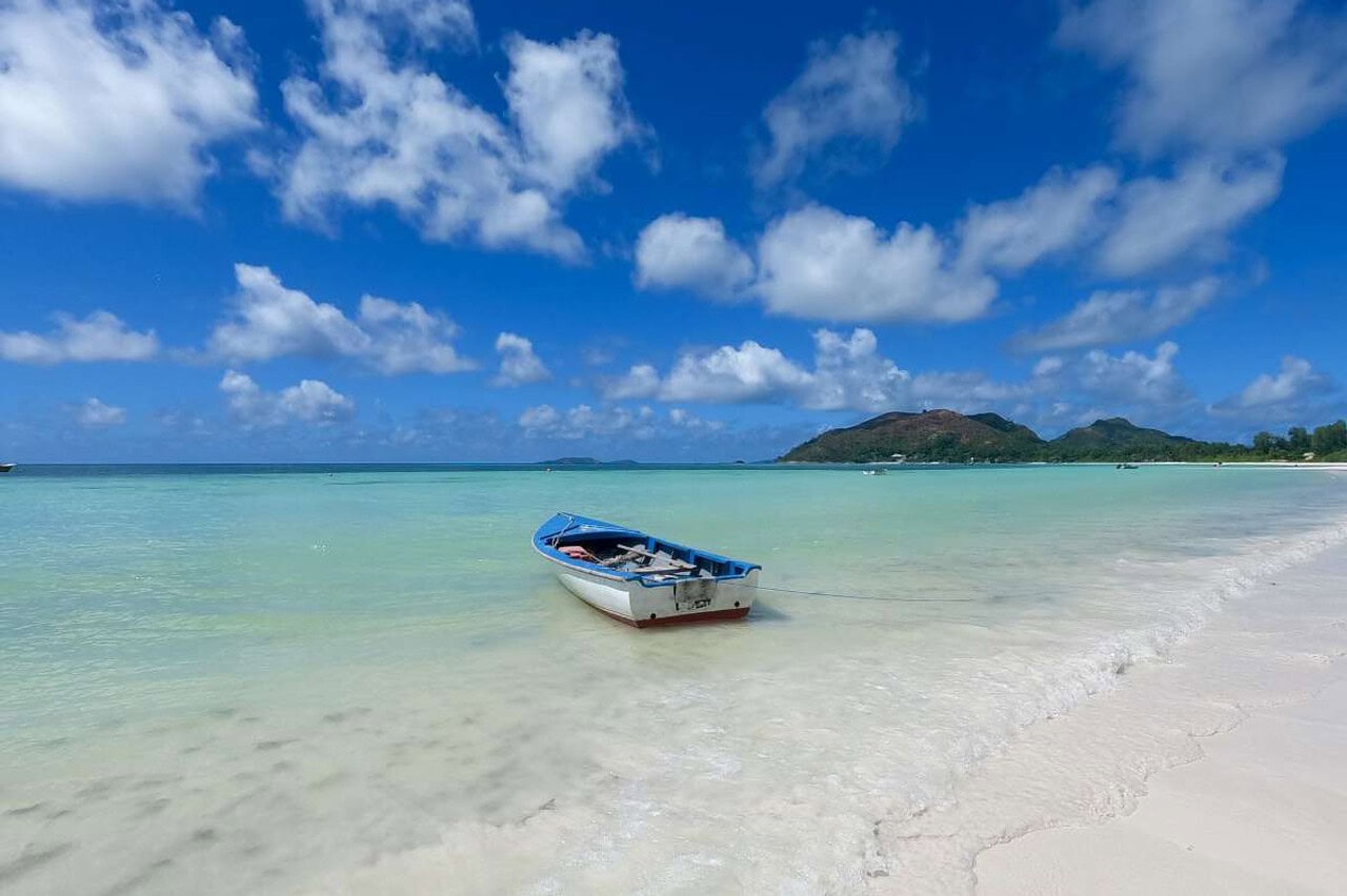 boat_in_anse_volbert_beach_praslin Small fisherman boat in the sea at Anse Volbert beach, one of the best areas to stay in Praslin, Seychelles