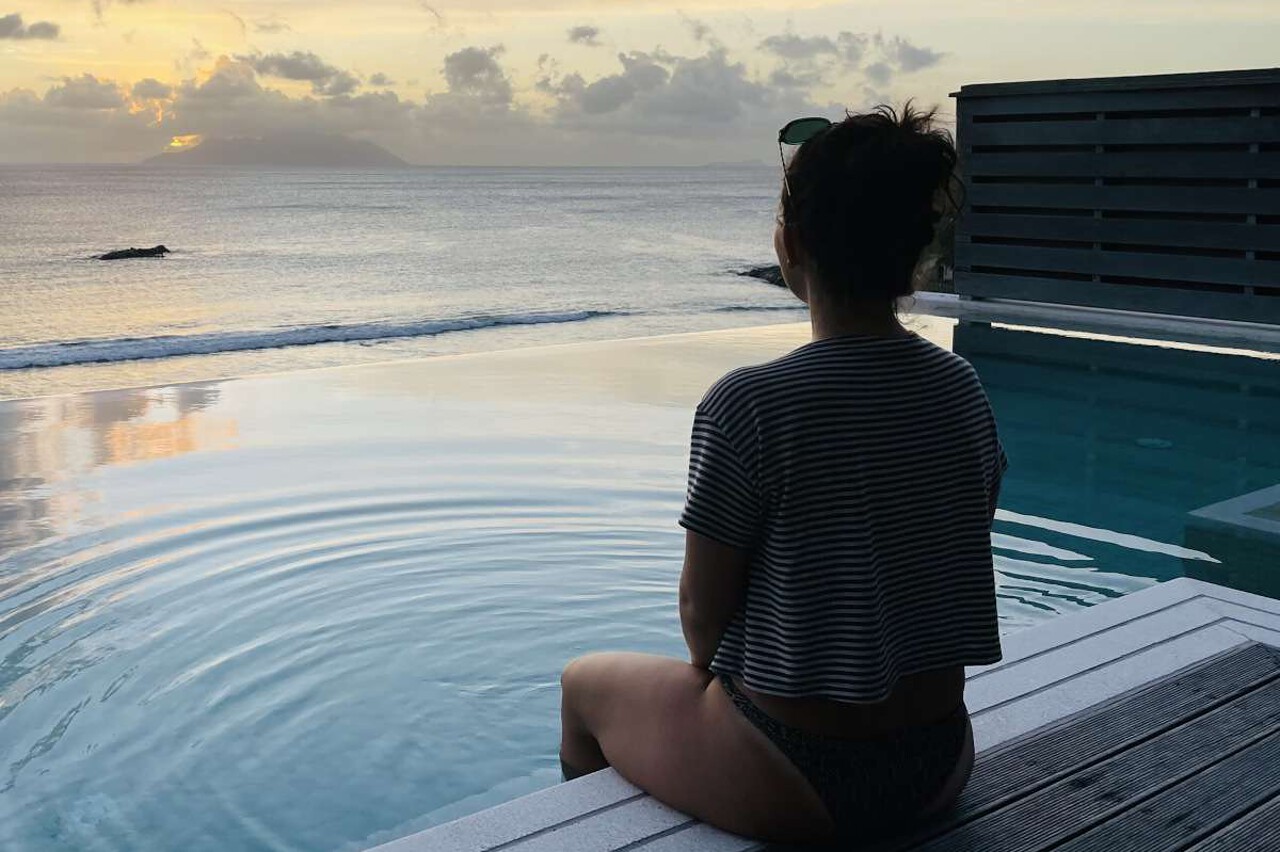 lady_looking_sunset_from_pool_villa Lady in a pool villa during honeymoon, overlooking the sea at sunset