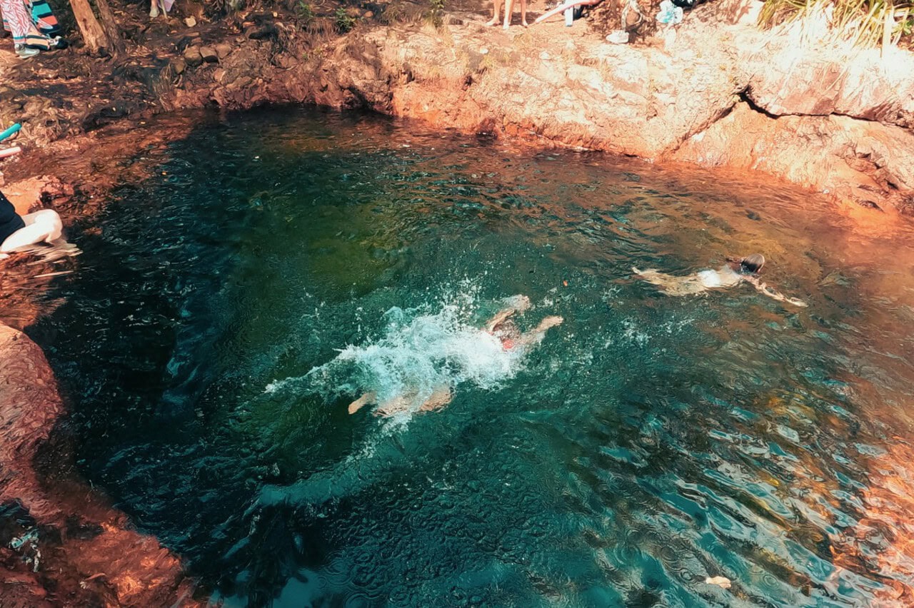 People swimming in a freshwater natural pool, one of the top things to do in a Litchfield National Park itinerary