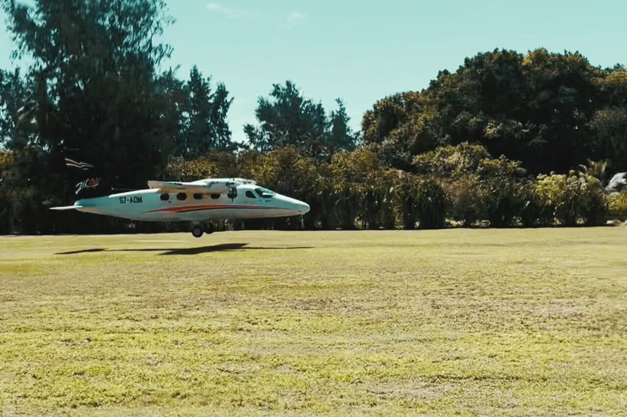 plane_denis_seychelles_landing Small airplane landing on grass runway in Denis Private Island