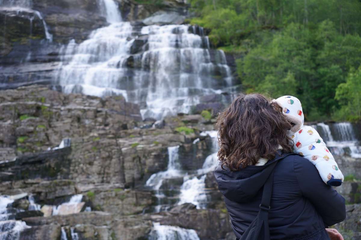 Mother and child looking at a waterfall in norway