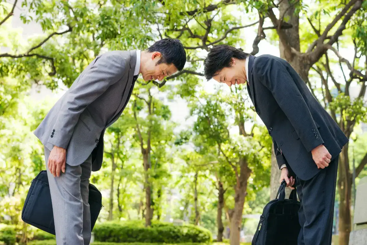 Two Japanese businessmen bowing to one another