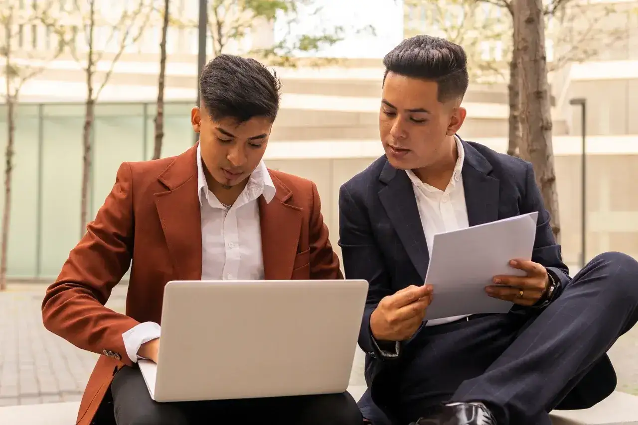Two Hispanic businessmen standing close to each other