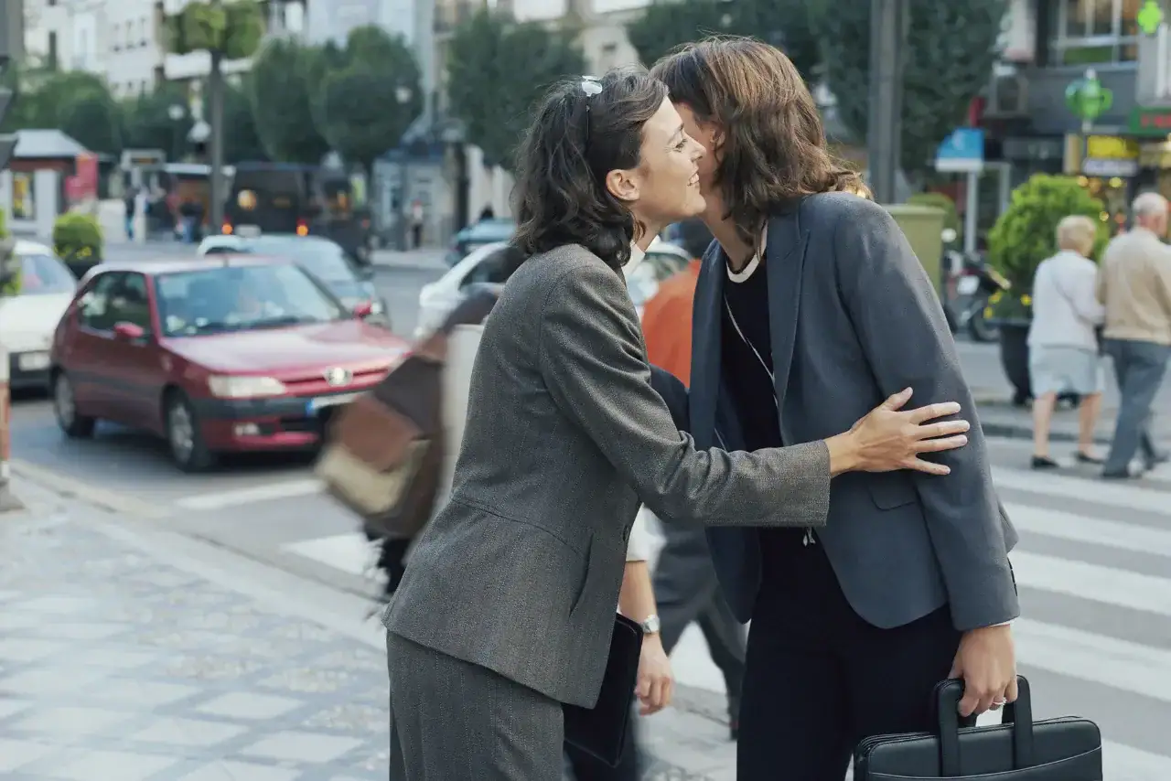 Two French business women greeting each other with a kiss on the cheek
