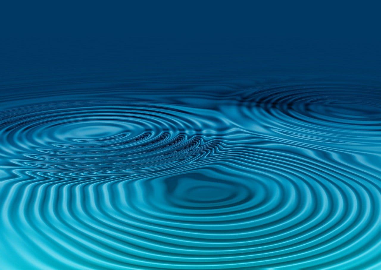 Abstrakte Wasseroberfläche mit kreisförmigen Wellen, symbolisch für Innovation und Technologie.