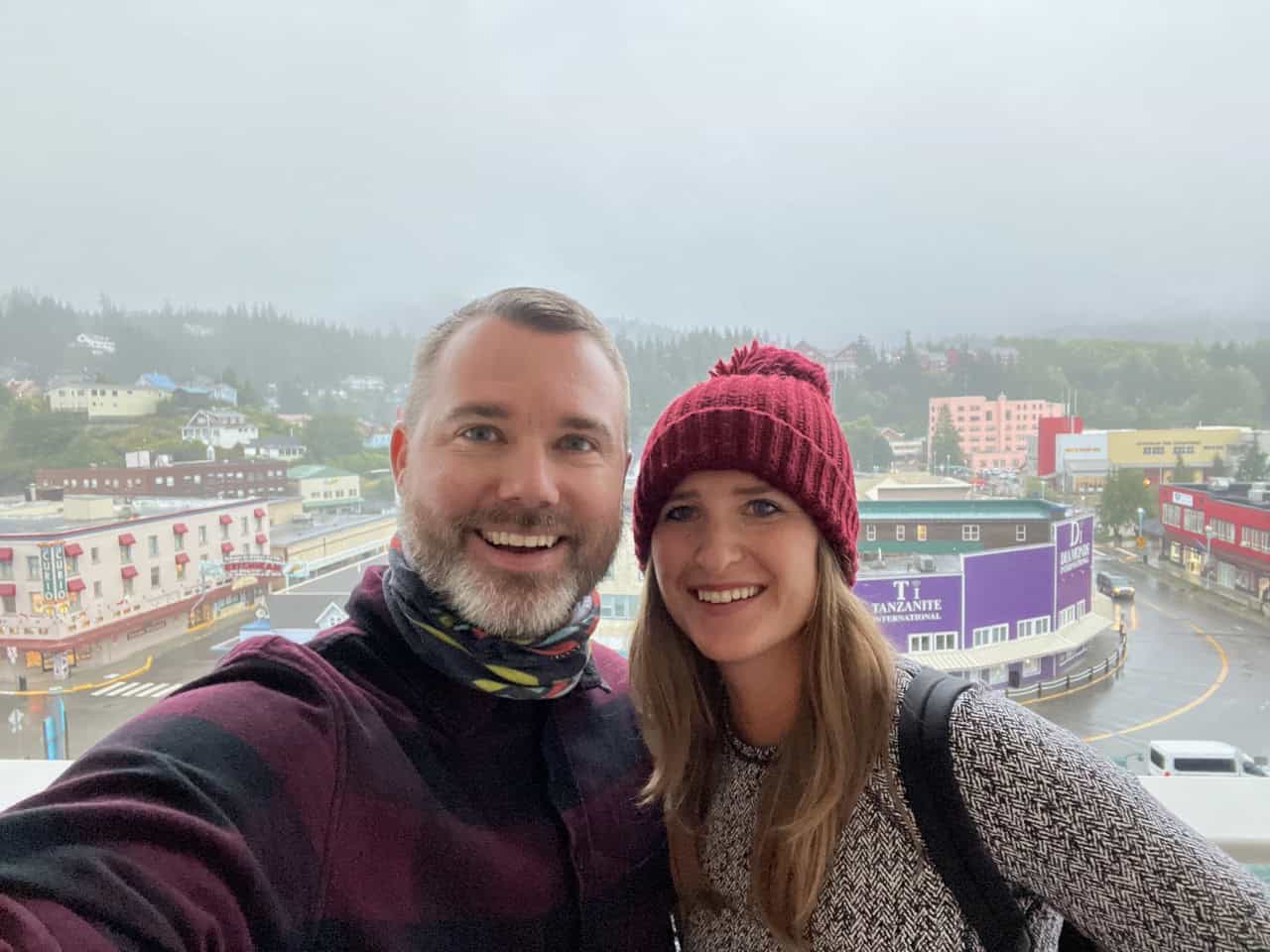 Vibrant couple enjoying a rainy day in downtown Gatlinburg, Tennessee, with colorful buildings and mountain views.
