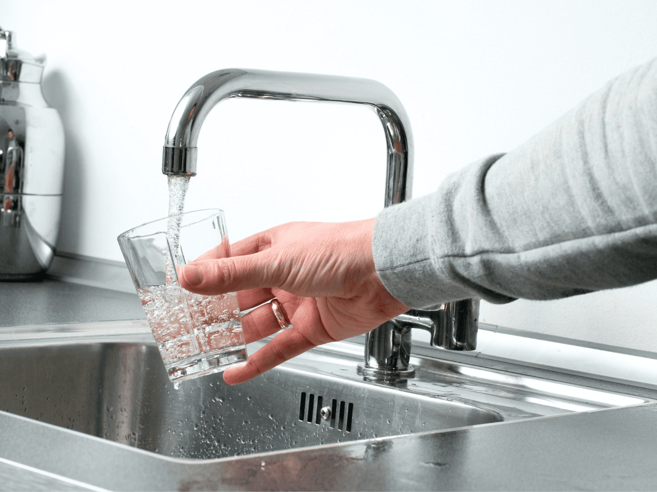 Man washing his hands under clean, running water at a sink