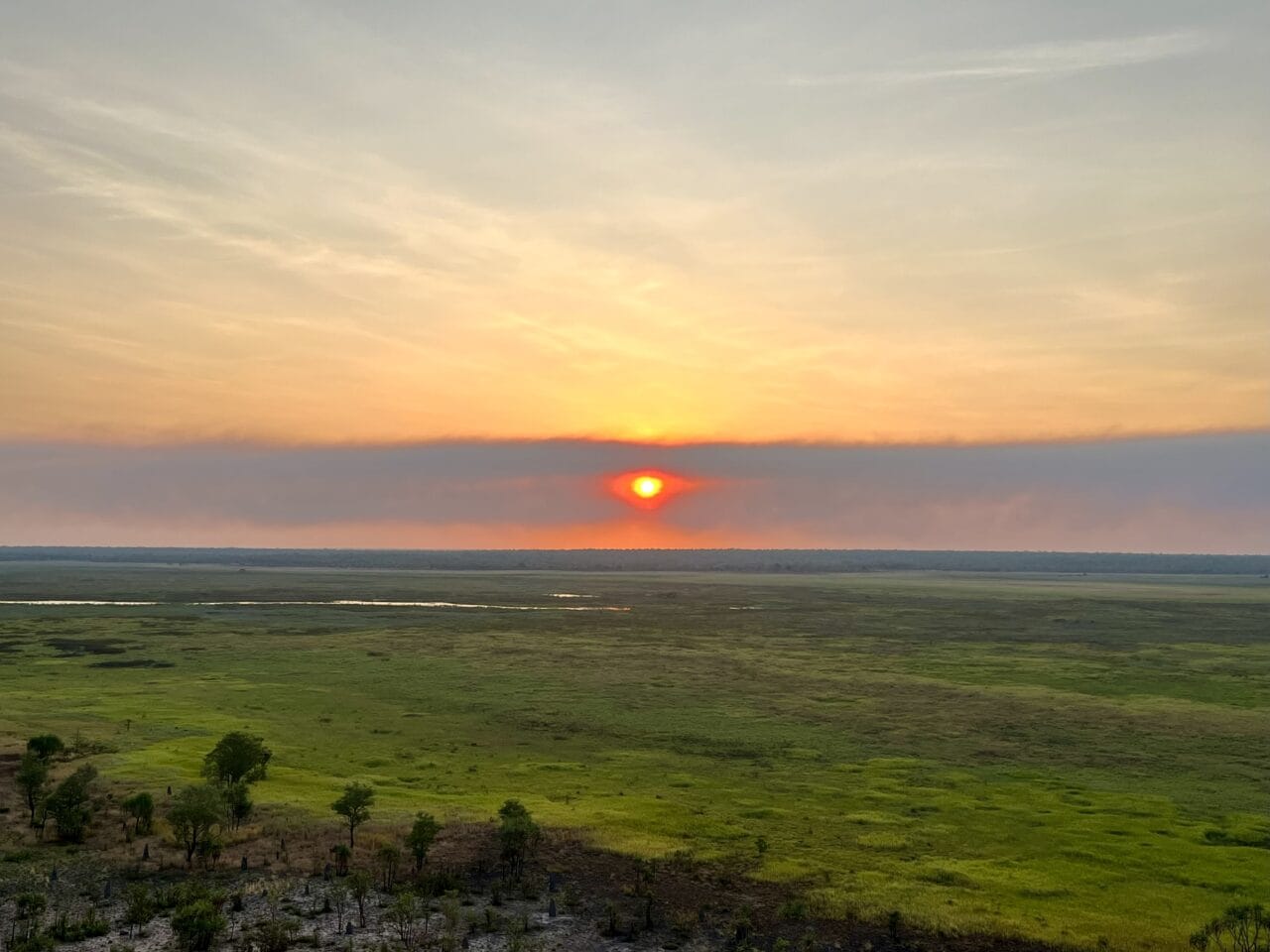 sunset over green plains from Ubirr viewpoint, one of the key highlights of a Kakadu itinerary