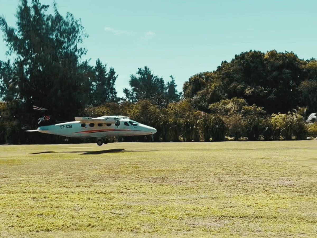 plane_denis_seychelles_landing Small airplane landing on grass runway in Denis Private Island