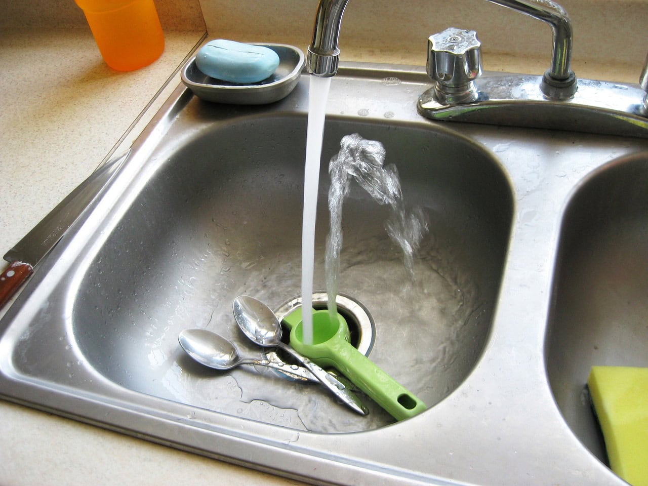 Stainless steel sink with what splashing upwards having turned the tap on.