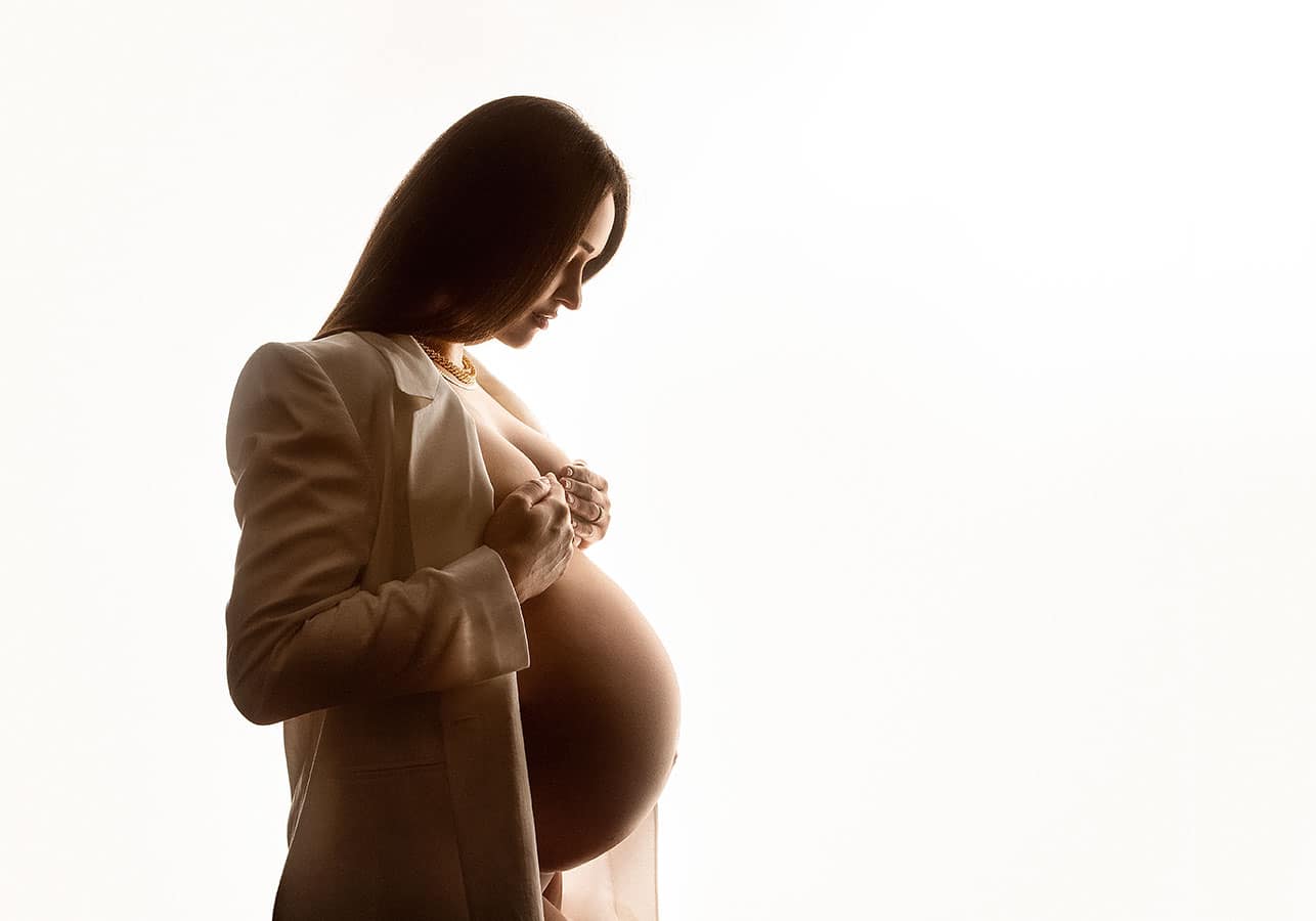 Kvinne med gravid mage i studio, portrett av graviditet, naturlig lys, konstnær fotografi, gravidfotografering, kunsten å fange følelser, vakker graviditetsfotoseanse, kvinne med mage, graviditet glamour.