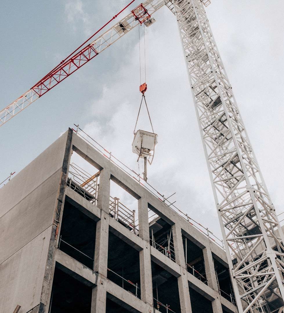 Crane lifting construction materials at a building site.