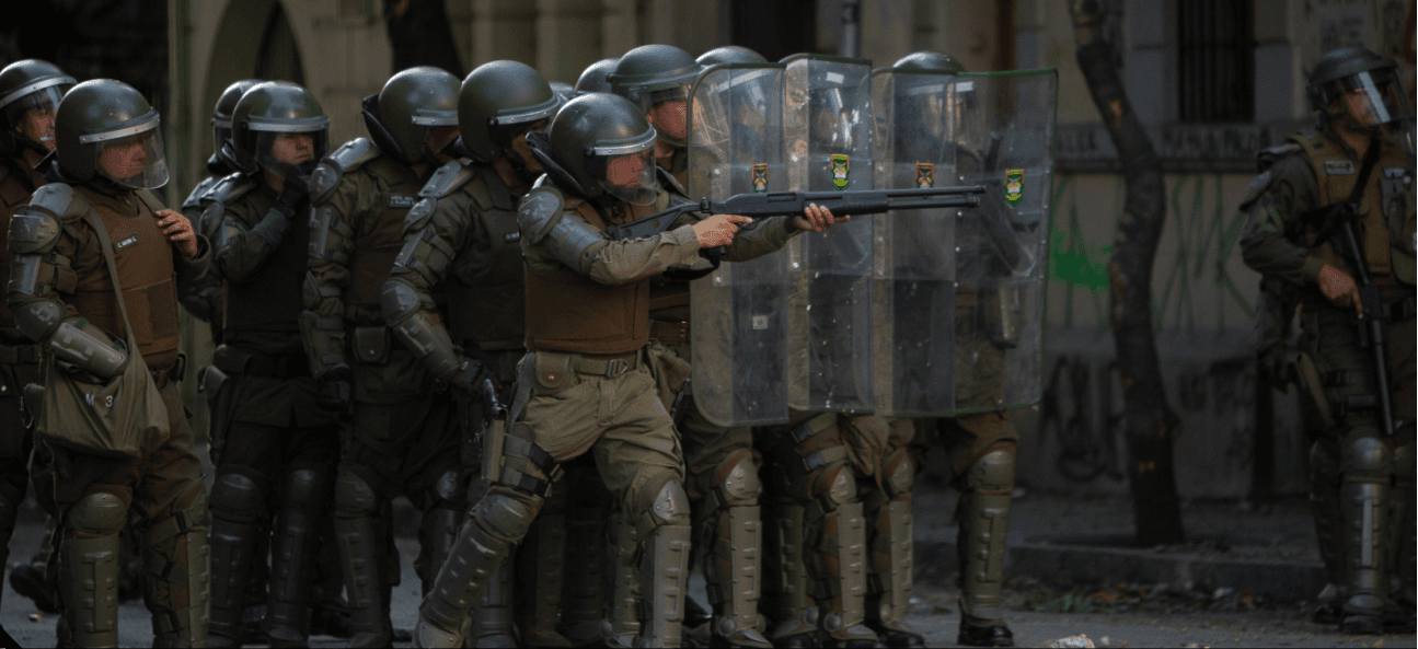 A carabineros aims his rifle