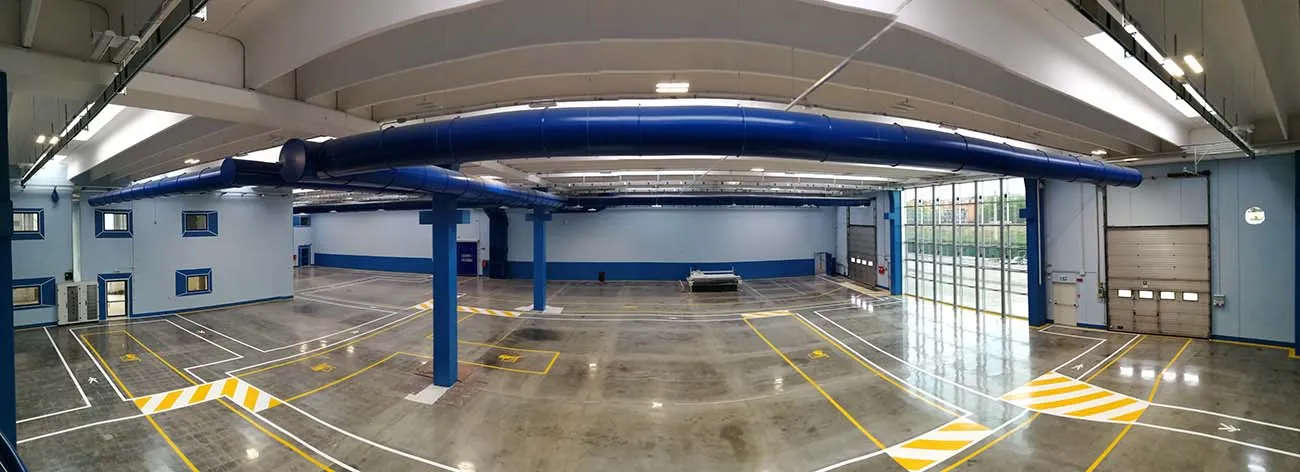 Segnaletica orizzontale a lunga durata UV resistente Prima Fast Line System® Prima Pavimenti — strisce e scritte polimerizzate ai raggi UV per corsie, aree di stoccaggio e vie di percorrenza in capannoni industriali e punti vendita ad altissimo traffico