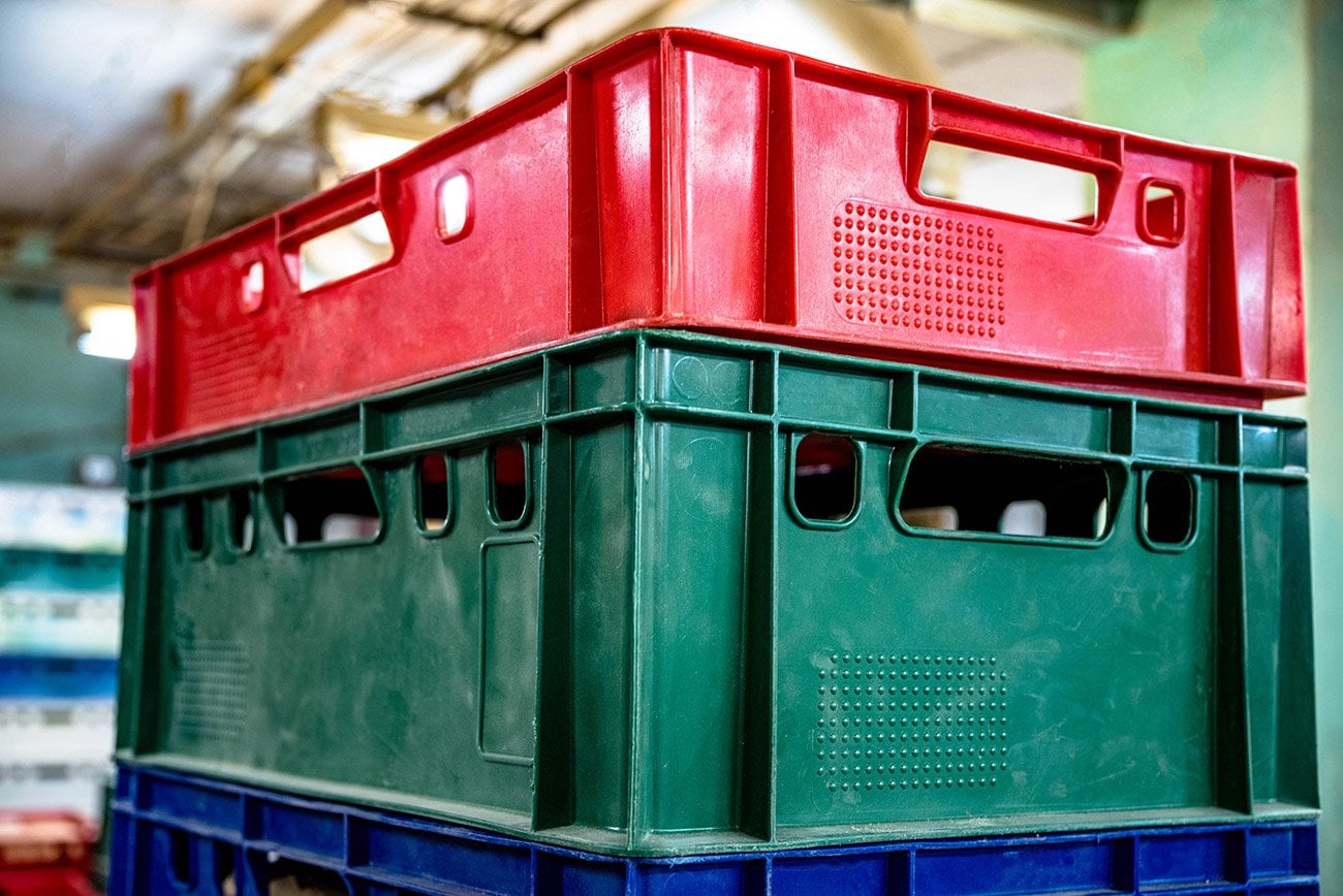 Stacked plastic crates in red, green, and blue colors.