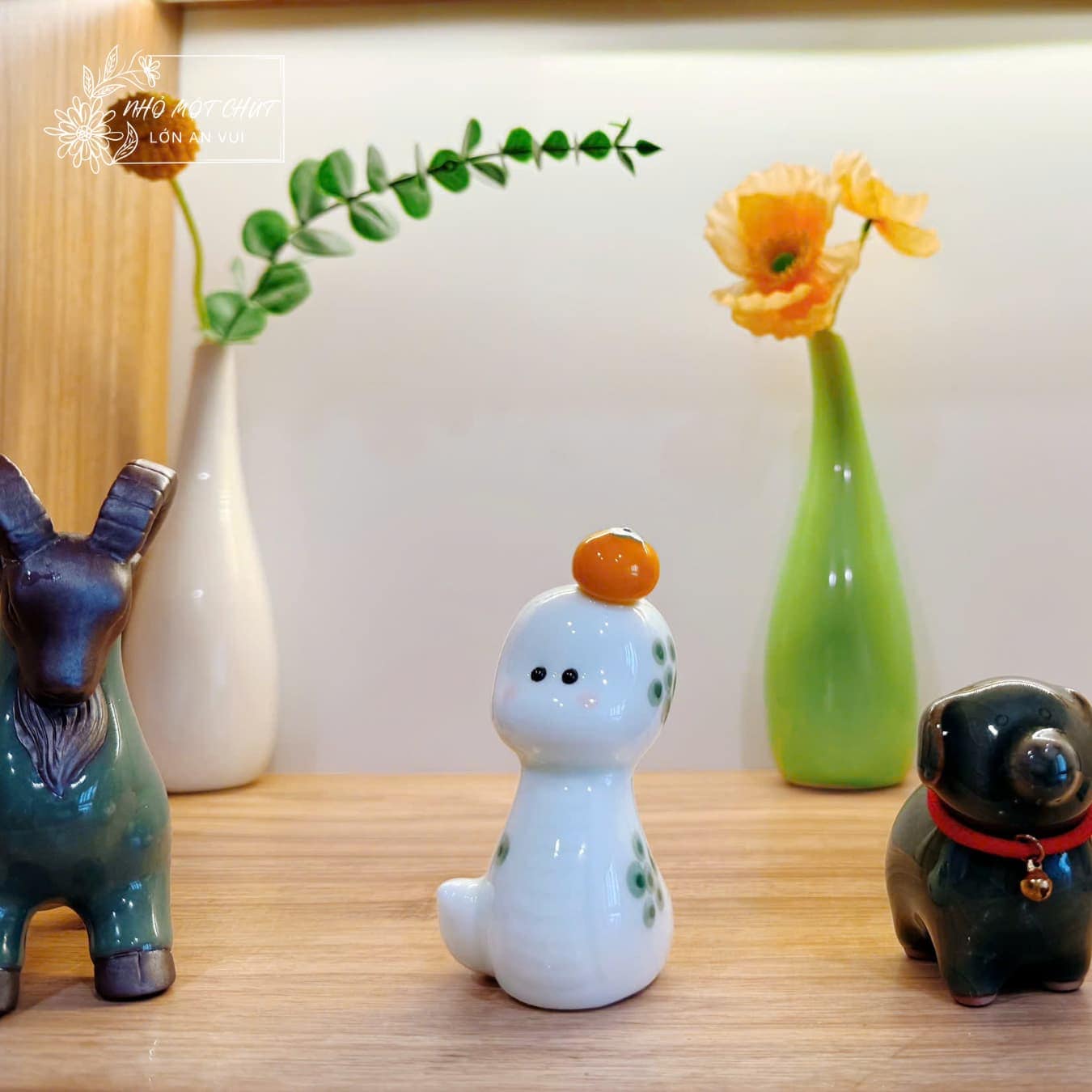 Rắn gốm An Tĩnh đội quýt trong góc decor bàn làm việc, kết hợp cùng bình hoa, cây xanh và các tượng gốm nhỏ.