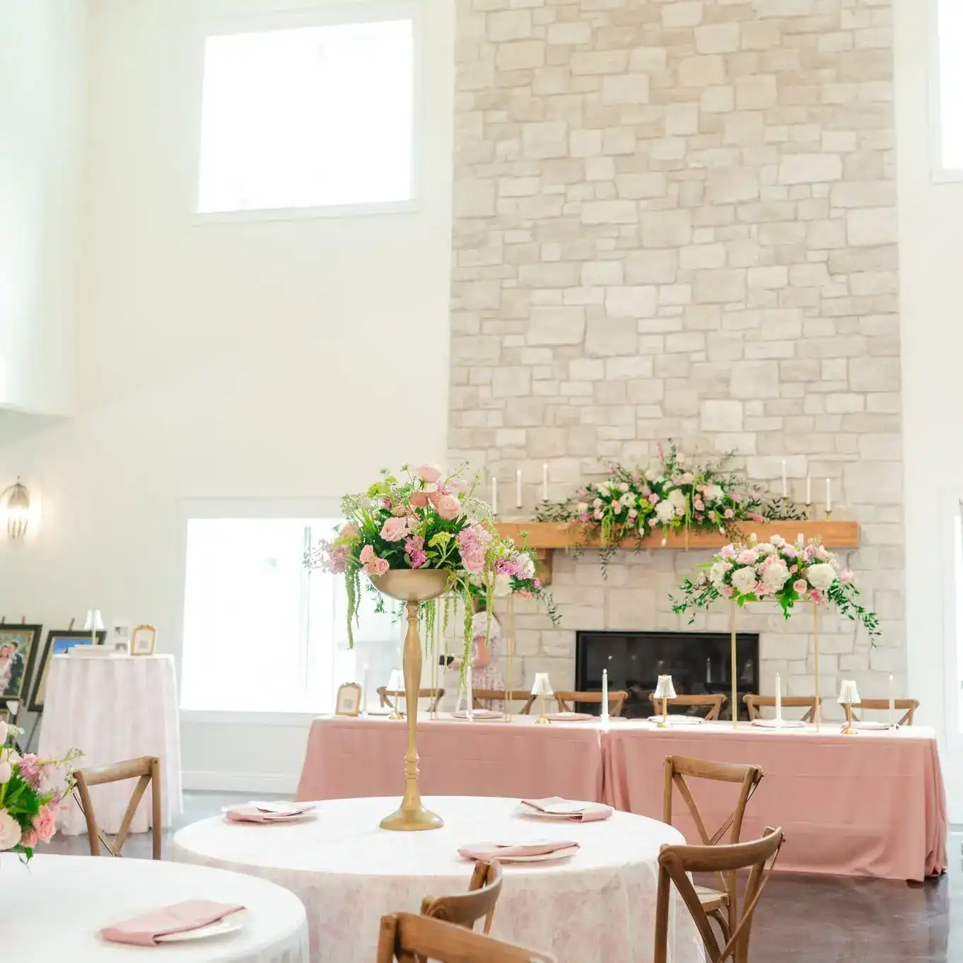 Stone fireplace mantel decorated with floral arrangements in the reception hall at Romaine Valley Weddings & Events in Fenton, Missouri